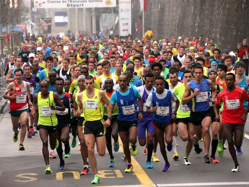 Départ d'une course élite de la Course de l'Escalade à Genève, peloton serré sous l'arche de départ
